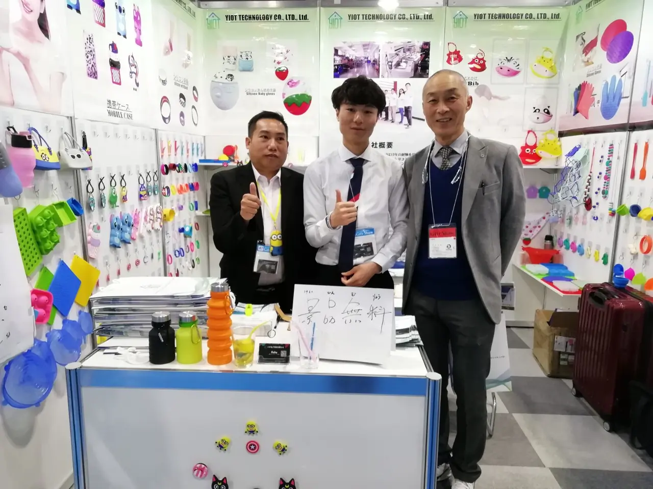 Team members and a visitor at an exhibition booth