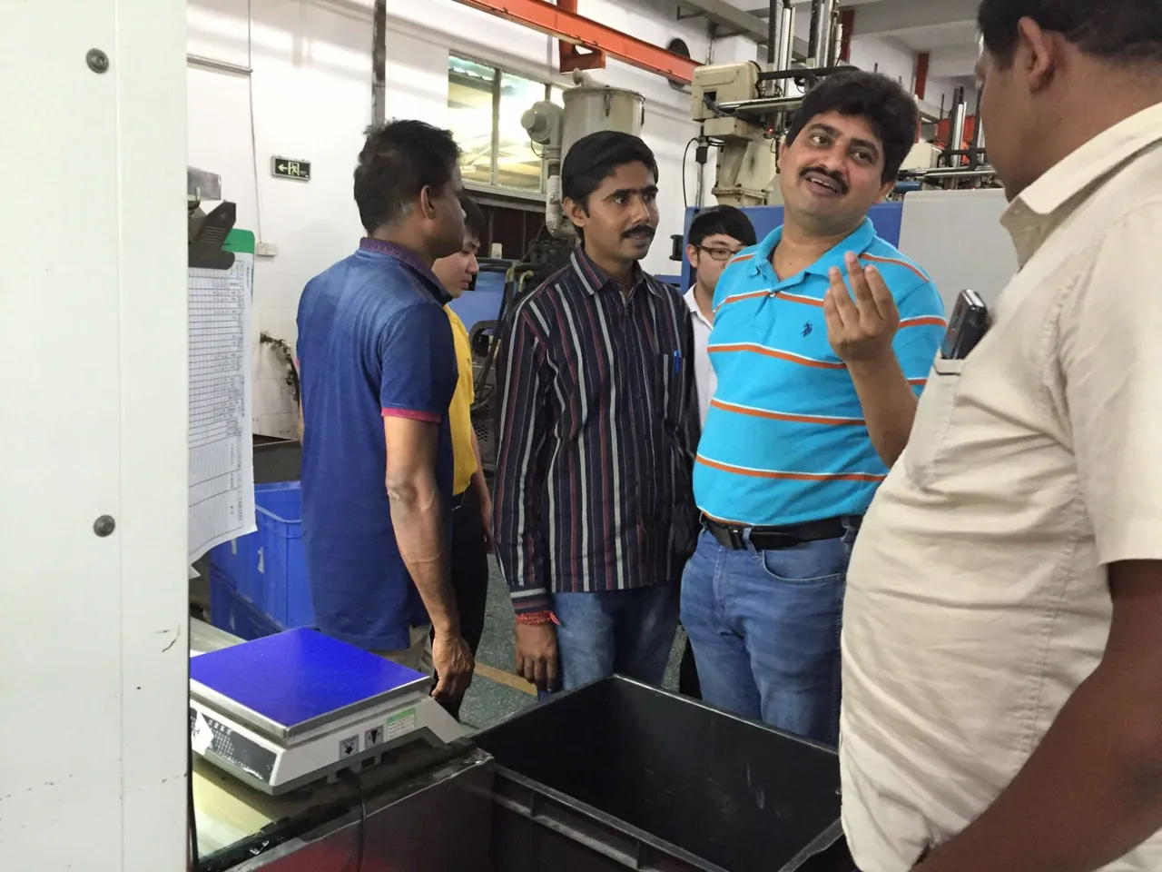 Visitors discussing production at a manufacturing workstation