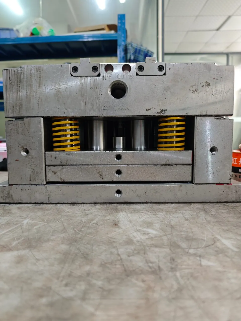 Ejector and spring arrangement in an injection mold assembly